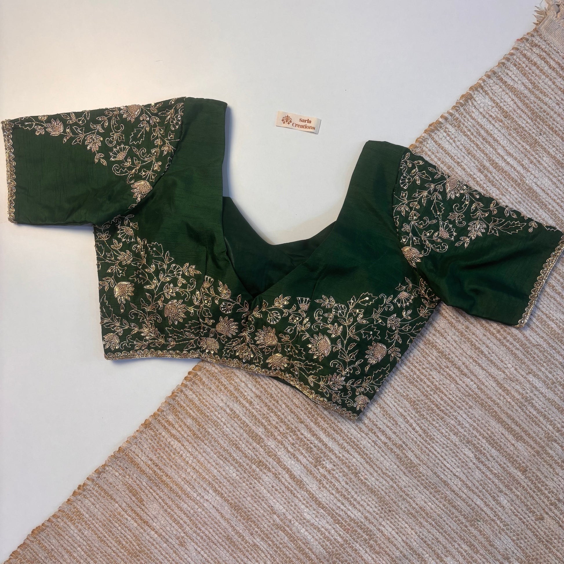 Green embroidered blouse on a textured surface
