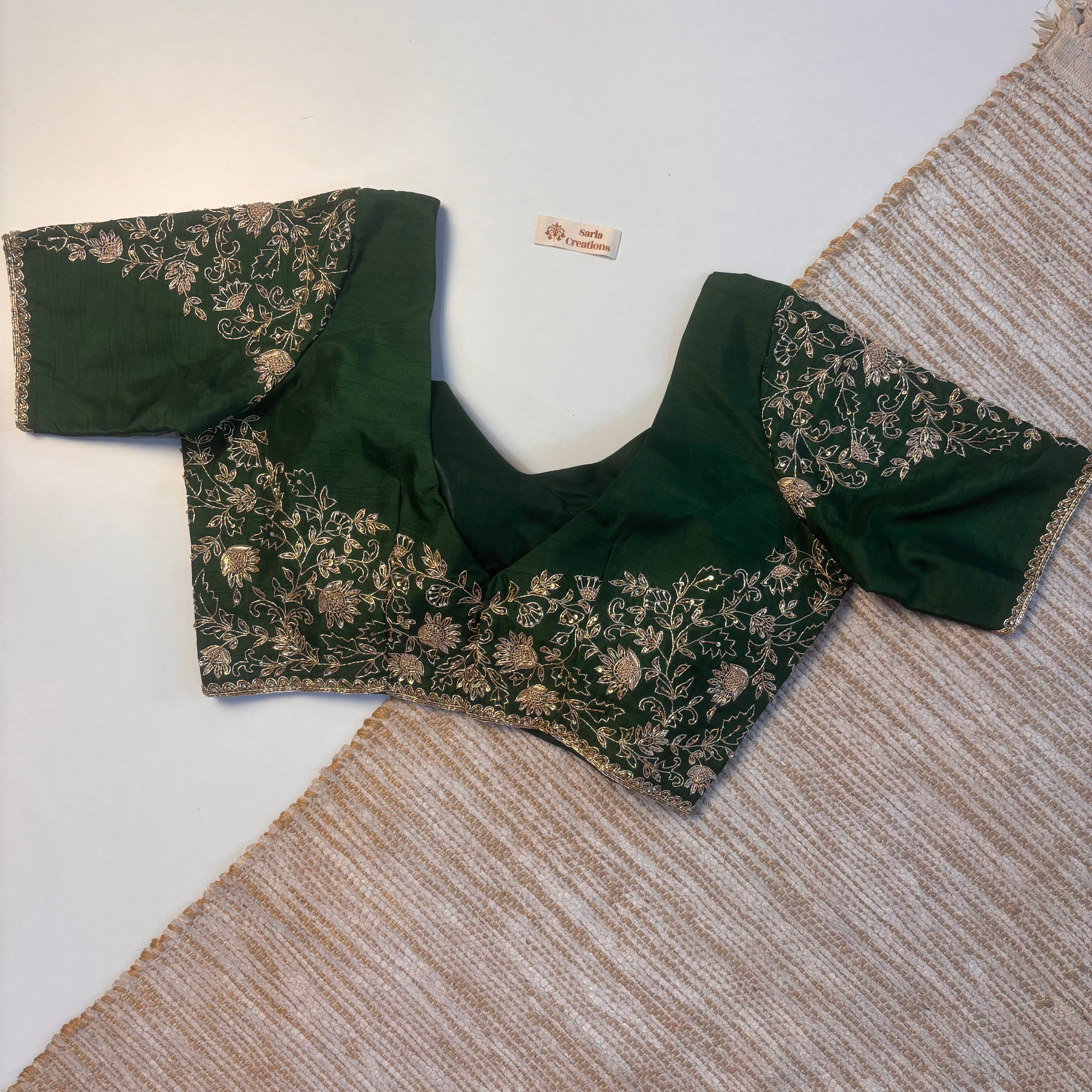 Green embroidered blouse on a textured surface